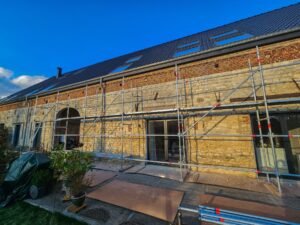 Échafaudage de façade monté devant une maison en pierre, en Brabant wallon