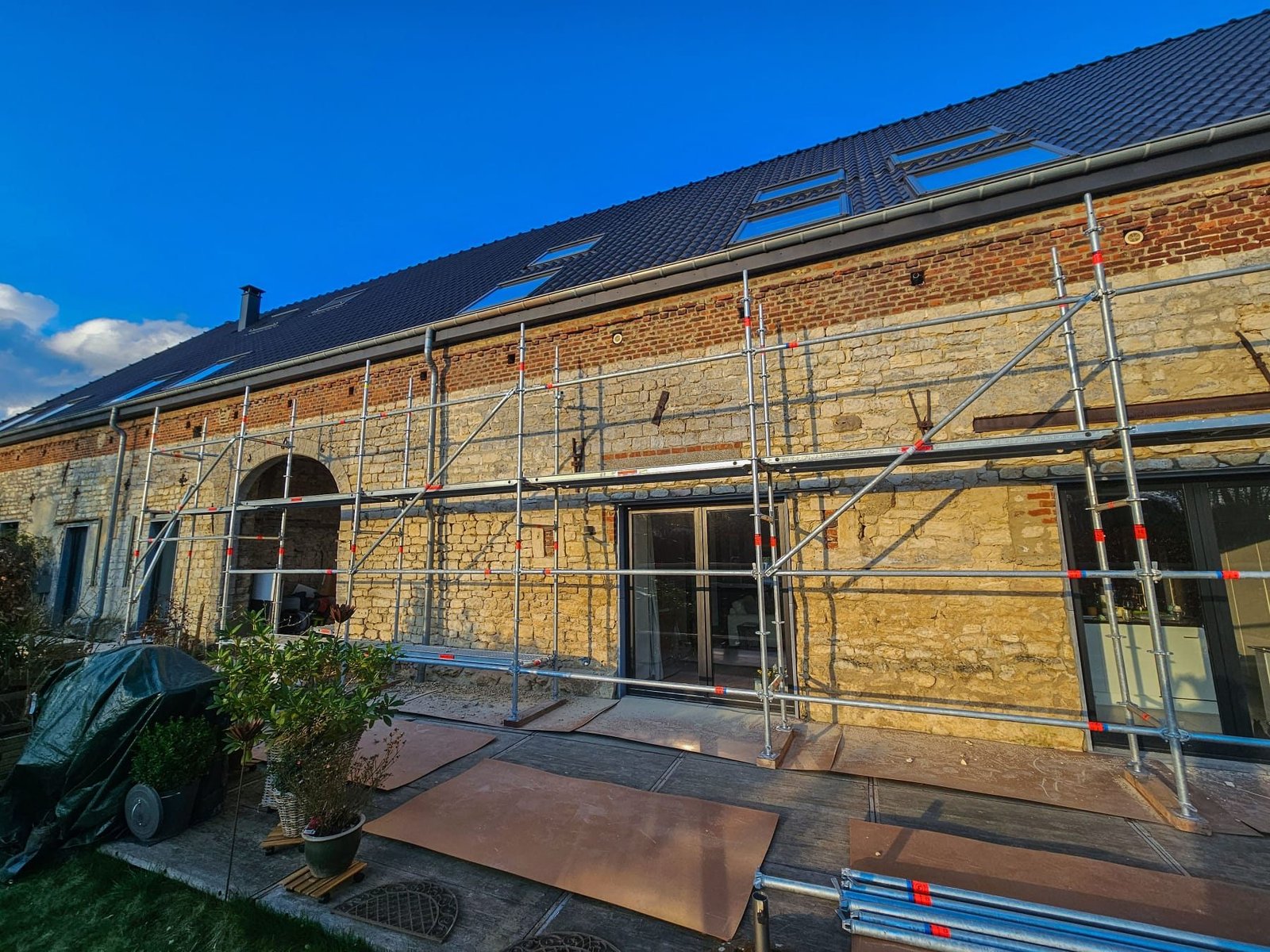 Échafaudage de façade monté devant une maison en pierre, en Brabant wallon